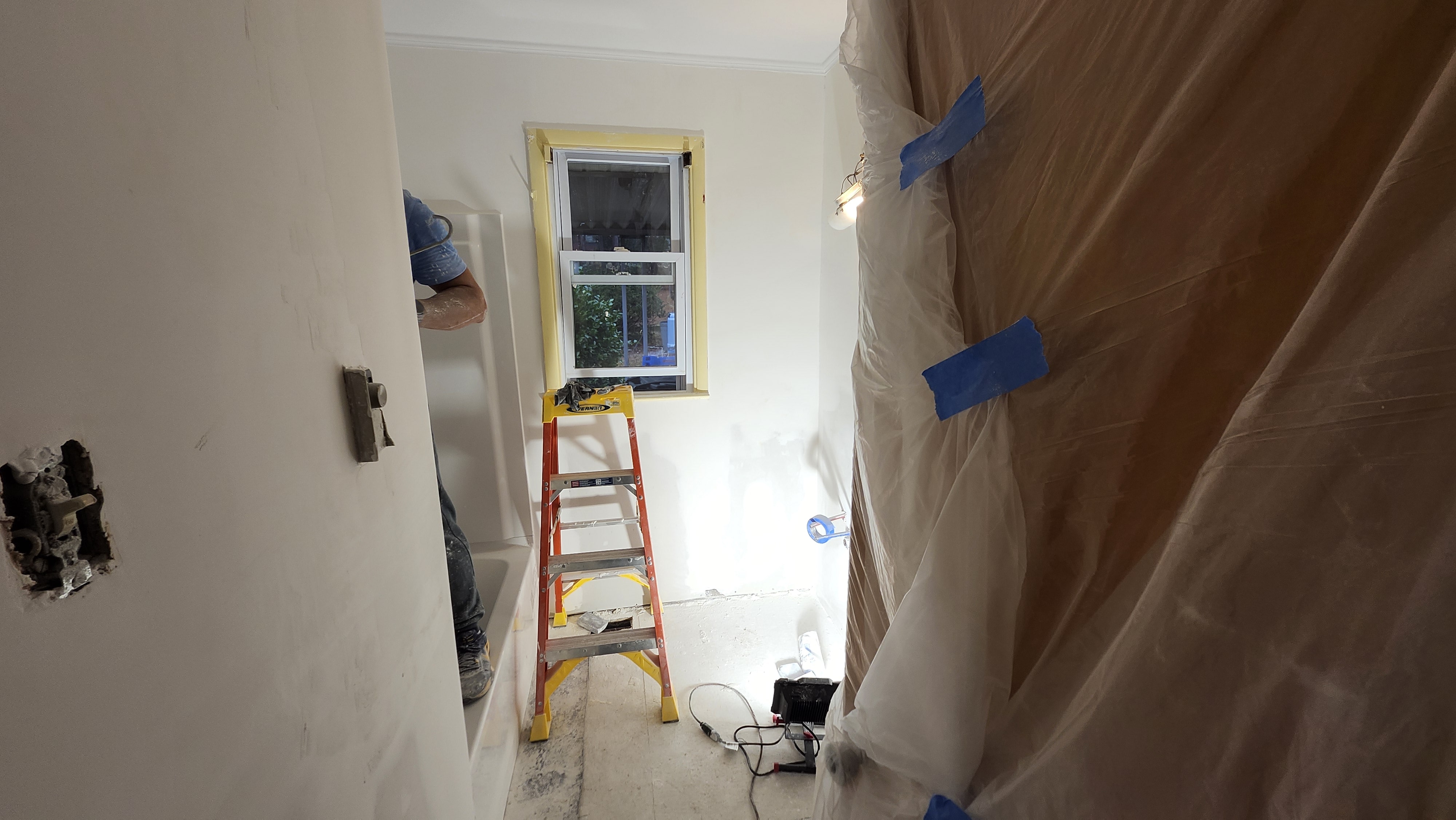 Hallway with renovation equipment and protective sheeting